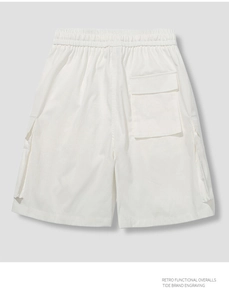 Detail view of retro white cargo shorts with functional pockets and elastic waist band