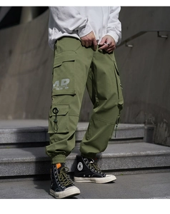 Detail of military green cargo pants with multi-pocket design and AR letter printing