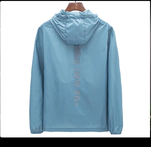Détail de la veste pare-soleil bleu clair montrant le logo UPF70+ sur un cintre en bois