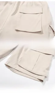 Detail view of light beige cargo shorts showing back pockets and loose leg openings