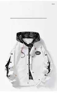 Detail of white hooded baseball jacket featuring black paisley patterns and KSJIE embroidery