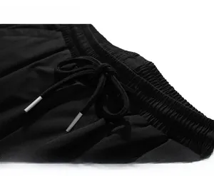 Detail of elastic waistband and durable drawstring with silver metal tips on black pants