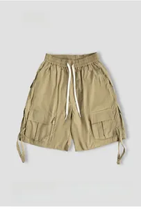 Detail view of khaki tactical cargo shorts showing elastic waistband and drawstrings