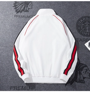 Close-up of white sports jacket featuring contrasting red and black side stripes on sleeves