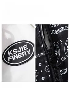 Detail of embroidered arm patch and metal zipper with paisley printed fabric on the jacket