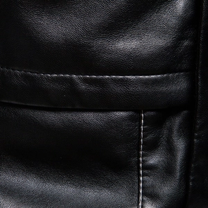 Close-up of black PU leather texture with contrast white stitching on men's jacket