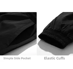 Detail of black utility cargo pants featuring side pockets and elastic cuffed hems
