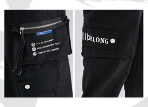 Detail view of black cargo pants featuring functional side zip pockets and printed design