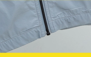 Détail de la couture de l'ourlet et fermeture éclair sur veste solaire bleu clair
