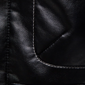 Macro detail of black grain leather jacket featuring high-contrast white stitching work