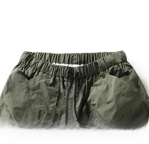 Detailed macro view of olive green cargo shorts featuring elastic waistband and drawstring