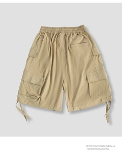 Detail of khaki cargo shorts showing elastic waistband and multi-pocket functional design