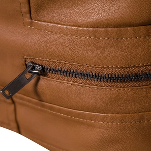 Detail of brown faux leather jacket showing lychee grain texture and metal zipper pocket