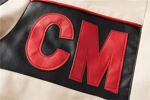 Detailed close-up of color-block faux leather jacket featuring red CM letter embroidery