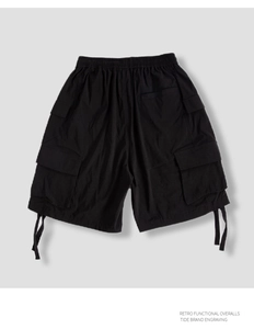 Detail of black functional cargo shorts featuring tactical multi-pockets and drawstring cuffs