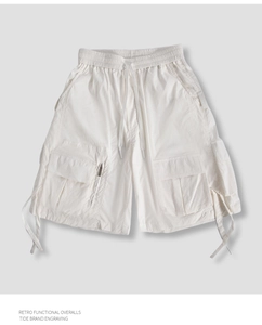 Close-up of retro functional cream cargo shorts with utility pockets and drawstrings