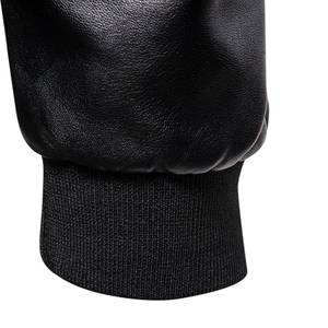 Close-up of black leather jacket cuff showing lychee grain texture and knitted ribbing