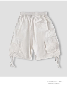 Detail view of white utility cargo shorts with elastic waist and large side flap pockets