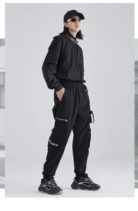 Streetwear cargo pants detail showing side pockets with LONG embroidery and silver zippers