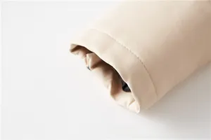 Detailed close-up of cream PU leather texture and stitching on the jacket sleeve cuff