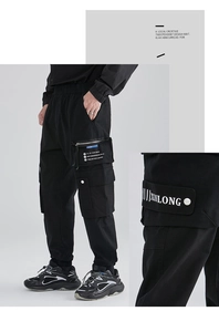 Macro detail of side cargo pockets with white lettering on black techwear pants