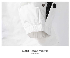 Detail of elastic cuffs and dark buttons on a white jacket with paisley patterned lining
