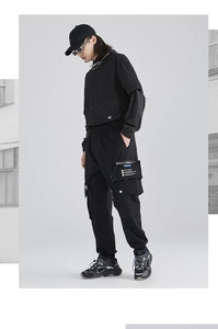 Detail of cargo pants side pocket with white printed text and functional design