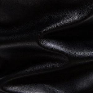 Close-up of black PU leather texture with fine grain and matte finish on a men's jacket