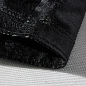 Macro detail of black PU leather jacket showing premium lychee texture and fine stitching