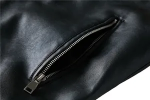 Macro shot of black faux leather grain texture with silver metal zipper pocket detail