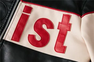 Close-up of 'ist' letter patch embroidery and silver metal zipper on leather jacket