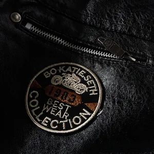 Close-up of motorcycle leather jacket with embroidered vintage crest and silver zipper