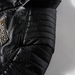 Close-up of quilted shoulder pads and logo patches on black faux leather biker jacket