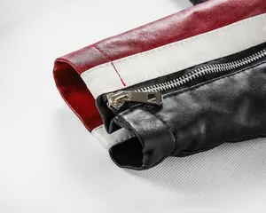 Détail de la manche d'une veste en cuir rouge et noir avec fermeture éclair métallique