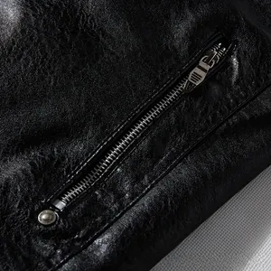Macro view of black PU leather jacket featuring a silver zipper and a fashion rivet