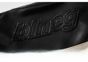 Close-up of black leather jacket featuring premium embossed 3D blneg textured lettering