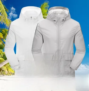 Detail view of lightweight white and grey hooded sun protection jackets on beach