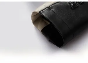 Macro shot of faux leather jacket cuff with beige contrast panels and reinforced stitching