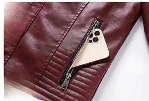 Detaillierte Makroansicht einer Metallreißverschlusstasche an einer dunkelroten Lederjacke