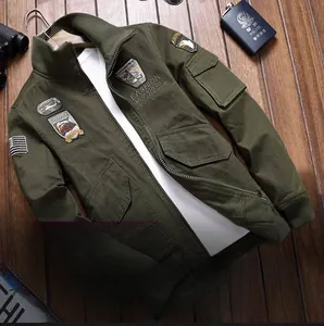 Detailed view of olive green military jacket with vintage patches on wooden background