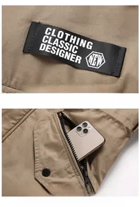 Détail d'une veste kaki avec poche zippée tactique et écusson brodé de créateur
