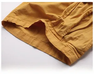 Detailed macro view of mustard yellow cargo shorts showing double-stitched hem and twill fabric