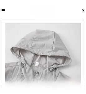 Detail of gray sun-protective jacket showing the adjustable hood and zipper closure