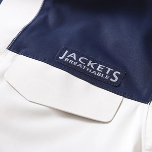 Detail of navy and beige outdoor jacket with breathable fabric and embroidered patch