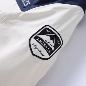 Detail of outdoor jacket sleeve featuring high-quality mountain embroidery and logo