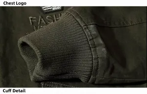 Detail of dark olive military jacket featuring ribbed cuffs and fashion embroidery badge