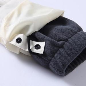 Close-up of winter jacket cuff showing waterproof fabric, fleece liner and metal snap button