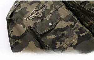 Close-up of military camouflage jacket featuring wing embroidery and metal snap pockets