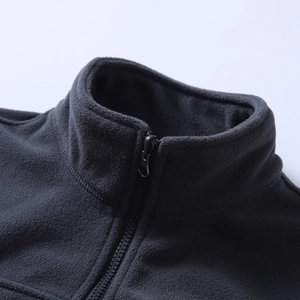 Close-up of a dark grey fleece jacket featuring a high collar and durable zipper detail