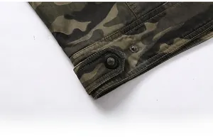 Macro detail of camouflage jacket hem featuring durable double stitching and matte metal snaps